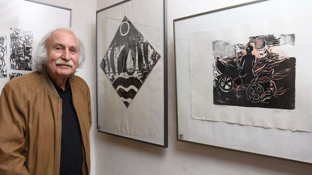 Alter Mann vor drei Grafiken