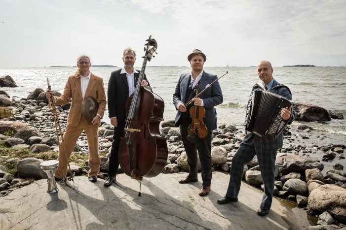 Vier Musiker mit Instrumenten am Meer