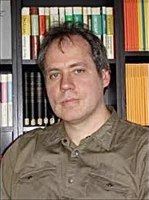 Portraitaufnahme eines Mannes vor einer Bücherwand